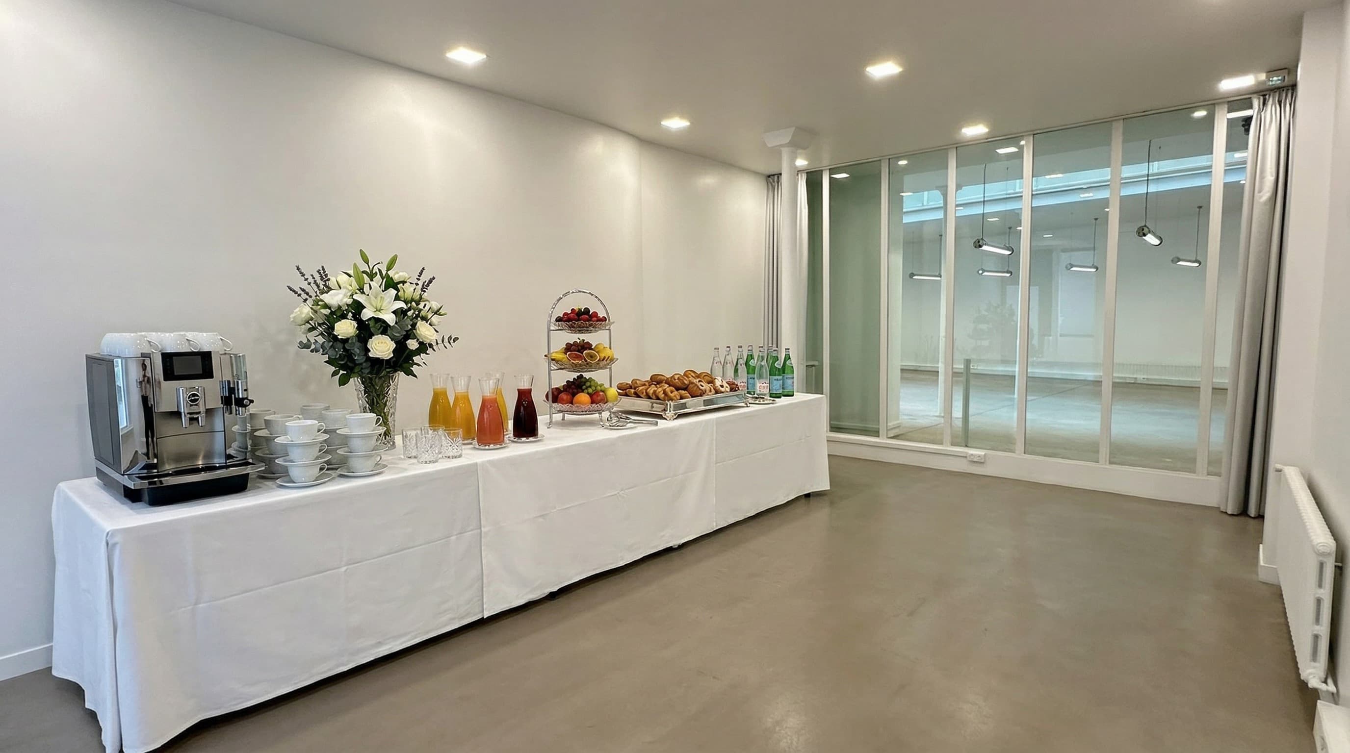 Buffet traiteur avec fleurs et viennoiseries dans la salle latérale