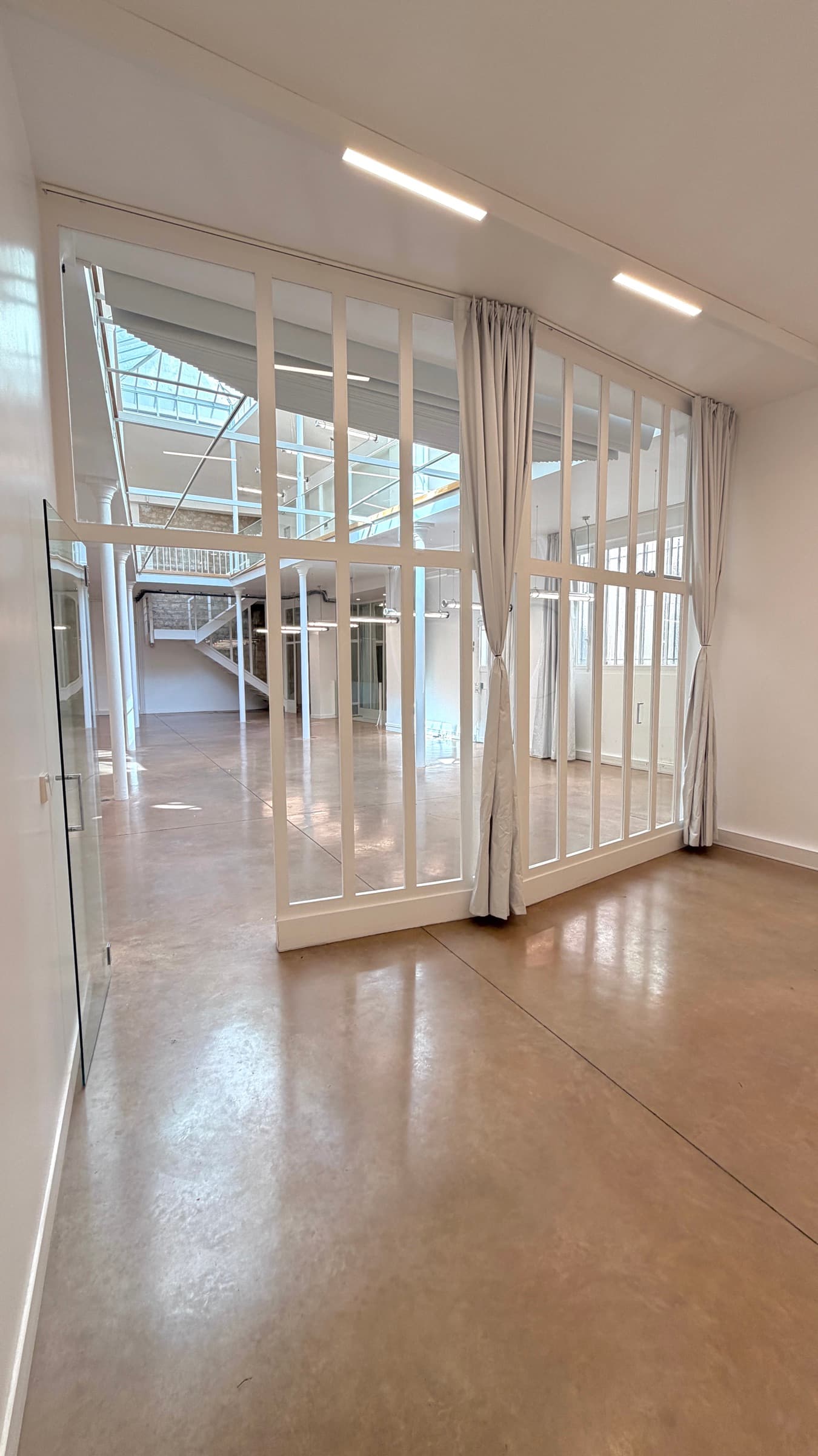 Cloison verrière vue de biais avec rideau et perspective sur le plateau