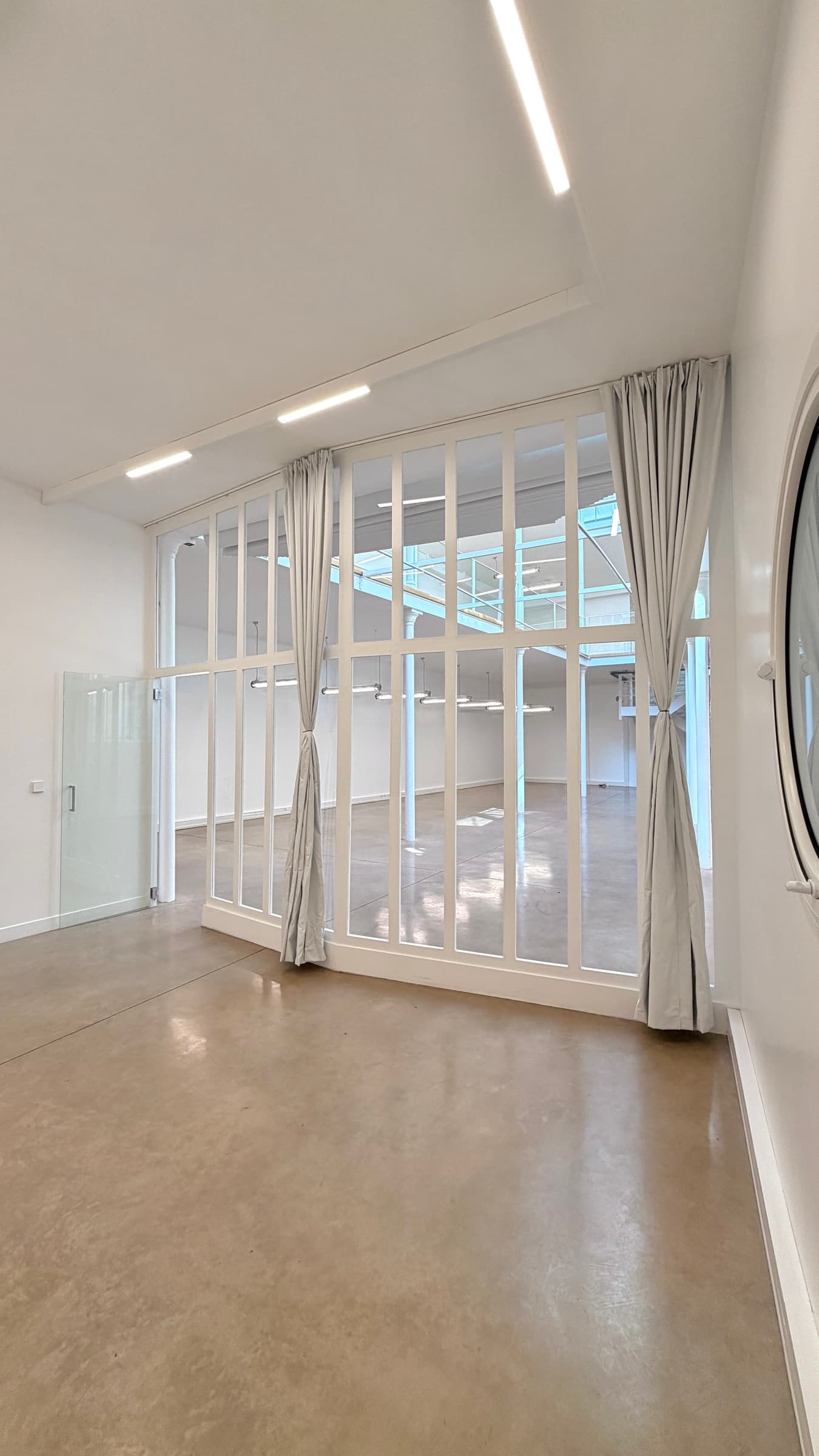 Bureau avec verrière intérieure et rideaux noués, vue traversante sur le plateau du Loft République